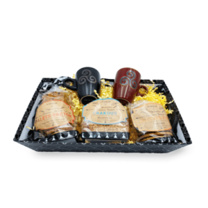 Photographie d'un panier traditionnel breton contenant trois paquets de gâteaux bretons et de deux tasses triskell.